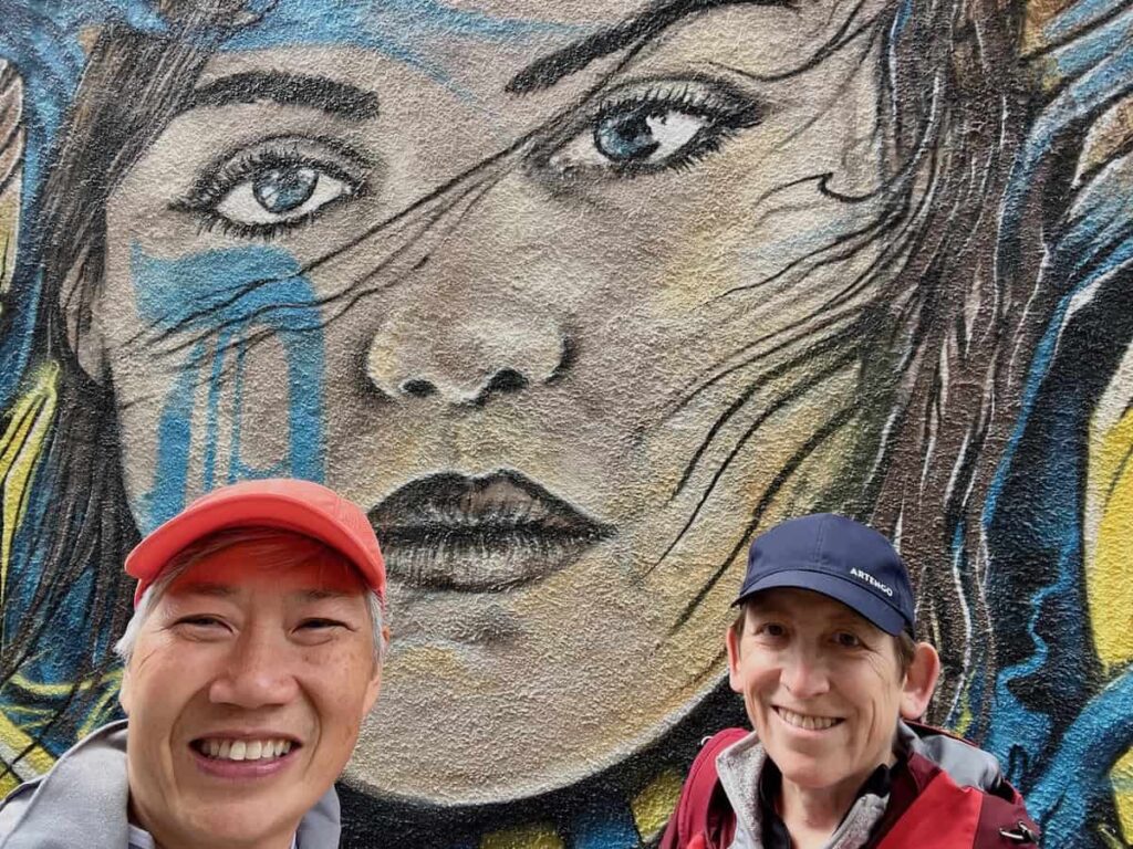 Sue & Reggie in Dunedin in front of Street Art.