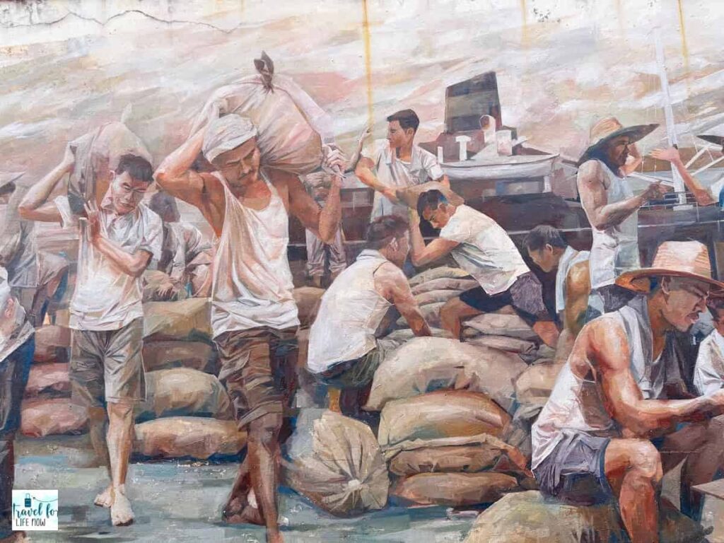 Mural of workers unloading sacks from a boat.