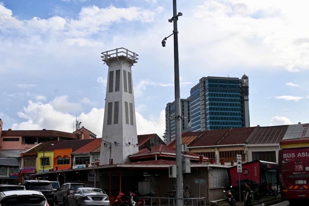 Picture of an open air market with an old fire tower.