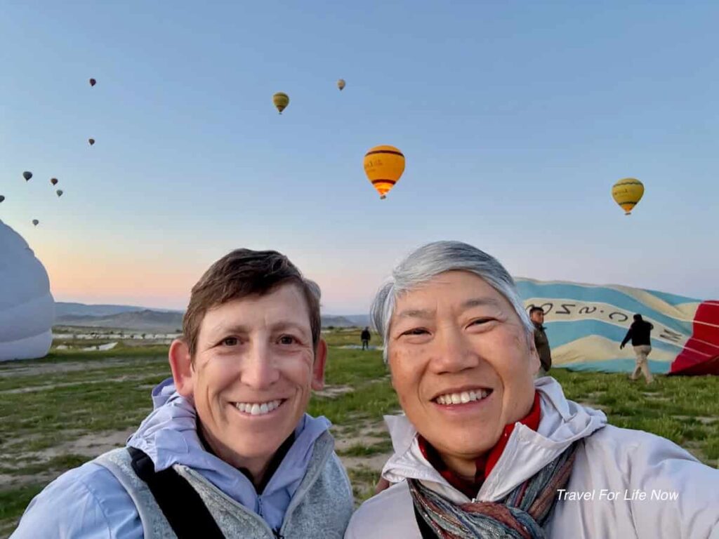 Two people on the ground with ballons partiallyinflated behind them